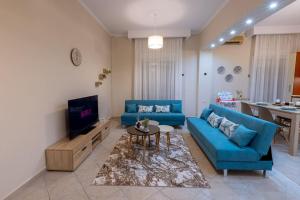 een woonkamer met twee blauwe banken en een tv bij Anna's House in Komotini