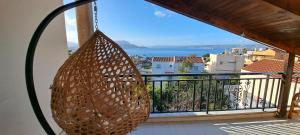 a rattan hanging from a balcony with a view of the ocean at Bicorna - Chania in Plaka