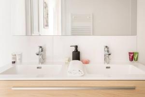 a white bathroom with two sinks and a mirror at SLEEPOO - Paradise 6 in Paris