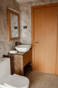 a bathroom with a sink and a toilet and a mirror at Saphir Boutique Hotel in Kigali