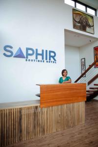 a woman standing behind a counter in a building at Saphir Boutique Hotel in Kigali