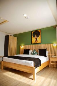 a bedroom with a large bed with green walls at Saphir Boutique Hotel in Kigali