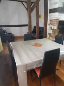 Maison à Troyes في تروي: طاولة بيضاء مع كراسي وطاولة مع