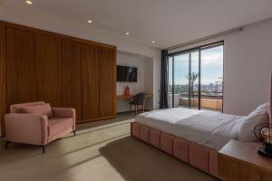 1 dormitorio con 1 cama grande y 1 silla en VILLA 103 - Luxury Getaway - Private Jacuzzi, en Marrakech