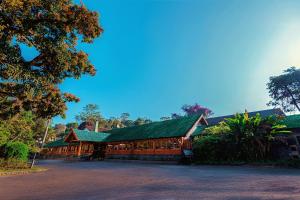 a large wooden building with a green roof at Bandarawela Hotel in Bandarawela