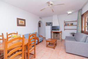 a living room with a table and a couch and a dining room at Bungalows Aparto Residence Galetamar in Calpe