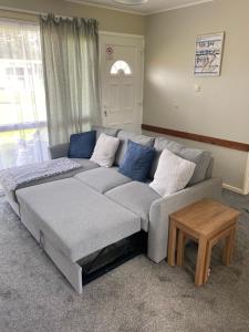 a gray couch in a living room with a table at Sunee Holidays Chalet in Hemsby