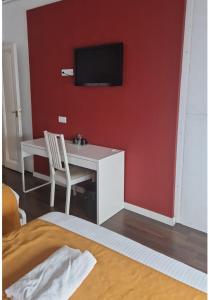 a room with a desk and a tv on a red wall at BruStar Gotic-Centric in Barcelona