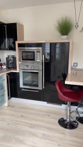 a kitchen with stainless steel appliances and a red chair at Zur Sonnenterrasse in Hemer