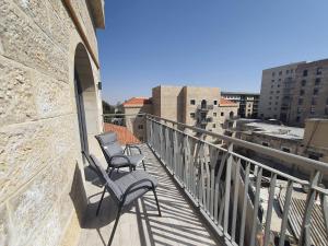 duas cadeiras sentadas na varanda de um edifício em Shirat Haneviim-Luxury Penthouse #Rental Israel em Jerusalém