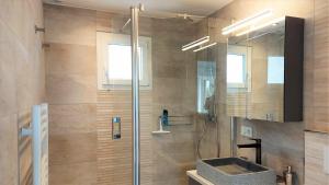a bathroom with a shower with a sink and a mirror at Le Refuge, 2 personnes, 4 étoiles tout confort in Annecy-le-Vieux