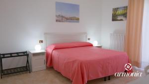 una camera con letto rosso e due comodini di B&B Armonia Vieste a Vieste