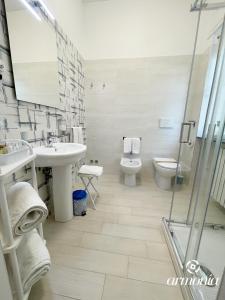 bagno con lavandino, servizi igienici e specchio di B&B Armonia Vieste a Vieste