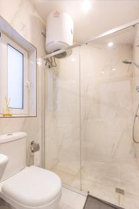 a white bathroom with a shower and a toilet at H1- Modern & Spacious 3 Bedroom Apartment in San Ġwann +33 photos