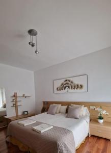 a white bedroom with a bed and a cross on the wall at Casa Maria in Olivenza