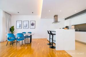 a kitchen and dining room with a table and blue chairs at LUX - The Bluewater Island Suite in Dubai