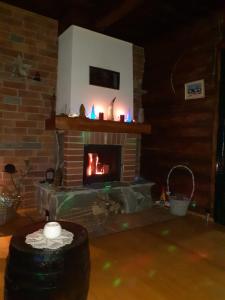- un salon avec une cheminée en brique et une bougie dans l'établissement Casa Hariton, à Drăguş