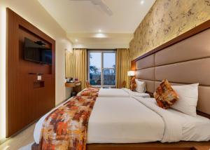 Cette chambre comprend 2 lits et une télévision. dans l'établissement Hotel Town Palace-Best Business Hotel in Bijapur, à Bijapur
