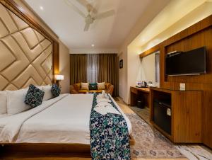 Cette chambre comprend un lit et une télévision à écran plat. dans l'établissement Hotel Town Palace-Best Business Hotel in Bijapur, à Bijapur