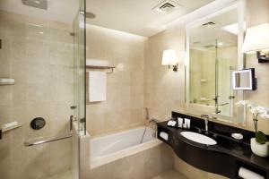 a bathroom with a sink and a tub and a shower at Crowne Plaza Doha West Bay, an IHG Hotel in Doha