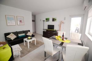 a living room with a couch and a table and chairs at Algarpraia in Carvoeiro