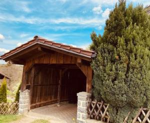 a wooden barn with a wooden door and a tree at Ferienwohnung Elisa in Tiefenbach