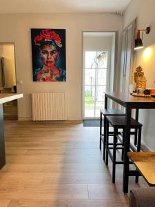 una sala de estar con una mesa y una pintura en la pared en Maison Coconing à Pacy sur Eure, en Pacy-sur-Eure