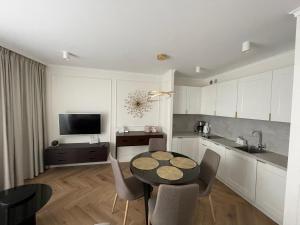 uma cozinha com mesa e cadeiras num quarto em Klif Apartamenty Nadmorskie Tarasy em Colberga