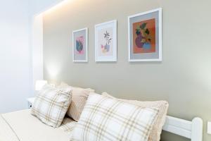 a bedroom with a bed with three pictures on the wall at Kos Olympia Apartment superior at Lambi beach in Kos Town +13 photos