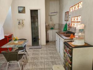 a kitchen with a table and a sink and a counter at Kitnet no 2º Piso, a 300m da Praia do Morro in Guarapari
