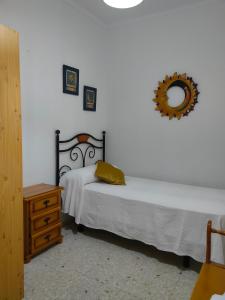 sypialnia z 2 łóżkami i lustrem na ścianie w obiekcie Casa Noria w mieście Conil de la Frontera