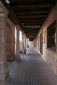a large stone building with a doorway leading to a hallway at Posada el Zaguan in Turégano