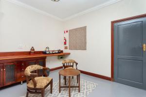 a kitchen with two chairs and a table and a door at Teak Place Guest Rooms in Krugersdorp +36 photos