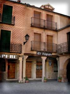 a large brick building with windows and balconies on it at Posada el Zaguan in Turégano