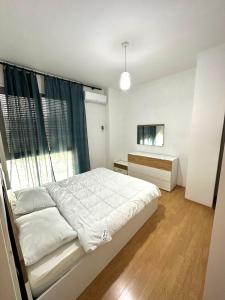 ein Schlafzimmer mit einem weißen Bett und einem Fenster in der Unterkunft Lake Escape - Home 2 in Tirana