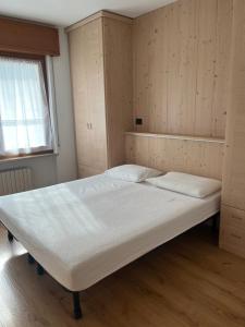 a large bed in a room with wooden floors at Casa Berlanda in Fiera di Primiero