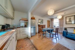 a kitchen and living room with a table and chairs at Music School Cottage 1 in Oundle