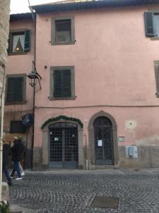 a large pink building with a door on a street at l'eco dei Papi in Viterbo