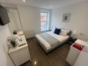 a small bedroom with a bed and a window at Corner Stone House - Apartment 1 in Great Yarmouth