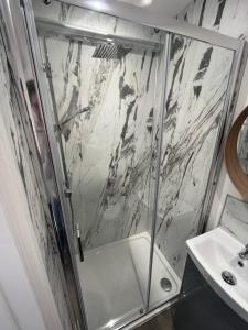a shower with a glass door next to a sink at Corner Stone House - Apartment 1 in Great Yarmouth