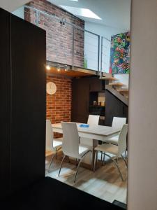 a dining room with a table and white chairs at Exclusive Art Apartment in Krakow