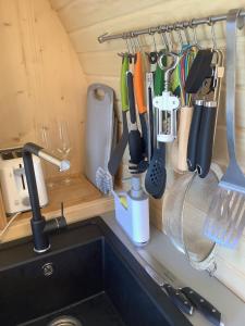 a bunch of kitchen utensils hanging on a rack over a sink at SkyFall in Woodbridge +17 photos