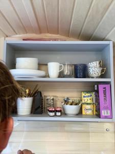 a person is looking inside of a cabinet with bowls and dishes at SkyFall in Woodbridge
