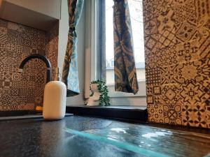 a soap dispenser sitting on a counter next to a window at Exclusive Art Apartment in Krakow