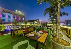 un restaurant avec des tables et des chaises et un bâtiment dans l'établissement Hotel Town Palace-Best Business Hotel in Bijapur, à Bijapur