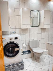 a bathroom with a washing machine and a toilet at KM Apparts 1 in Wesel