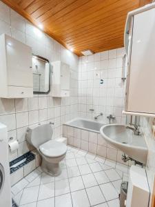 a bathroom with a toilet and a sink and a tub at KM Apparts 1 in Wesel