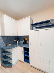 cocina con armarios blancos y encimera azul en KM Apparts 1, en Wesel