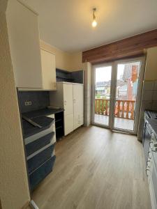 a kitchen with white cabinets and a large window at KM Apparts 1 in Wesel