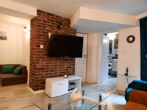 a living room with a tv on a brick wall at Exclusive Art Apartment in Krakow